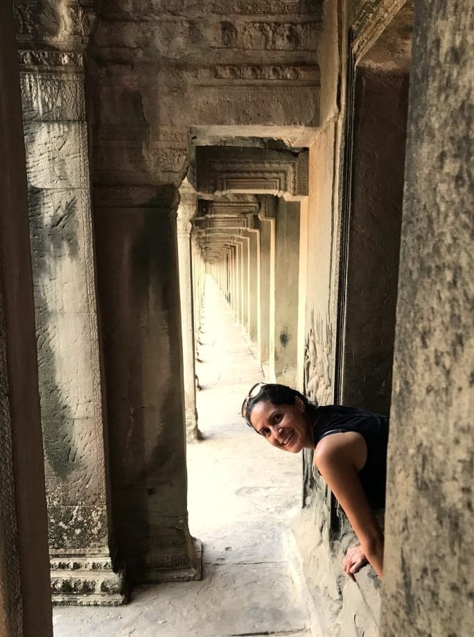 Yazmín Prado sonriendo desde un pasillo de templo antiguo, imagen simbólica de retorno interior y presencia
